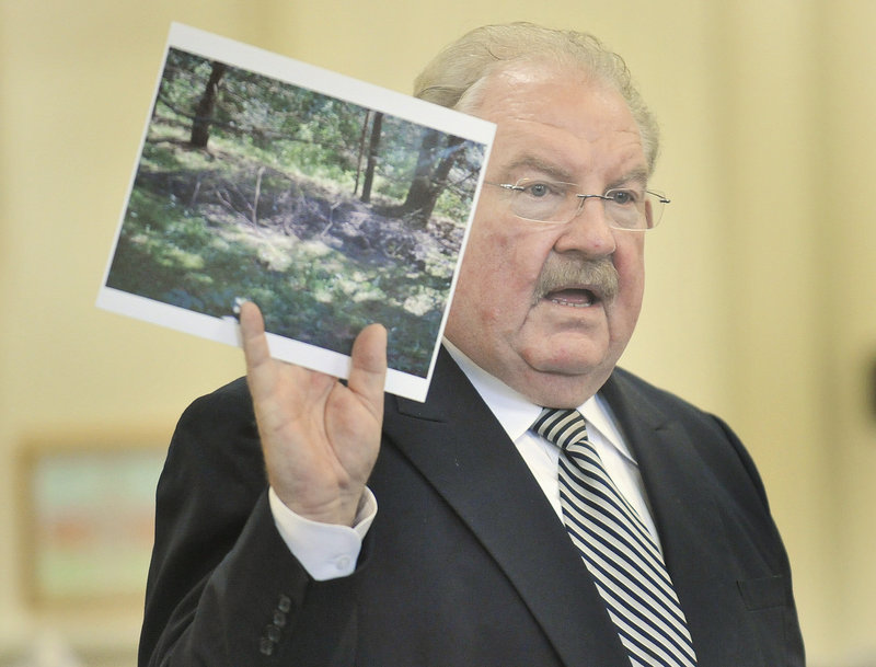 Defense attorney Daniel Lilley holds a photograph of the site where Kelly Gorham s body was buried in New Hampshire while addressing the jury during closing arguments in the murder trial of Jason Twardus on Thursday.