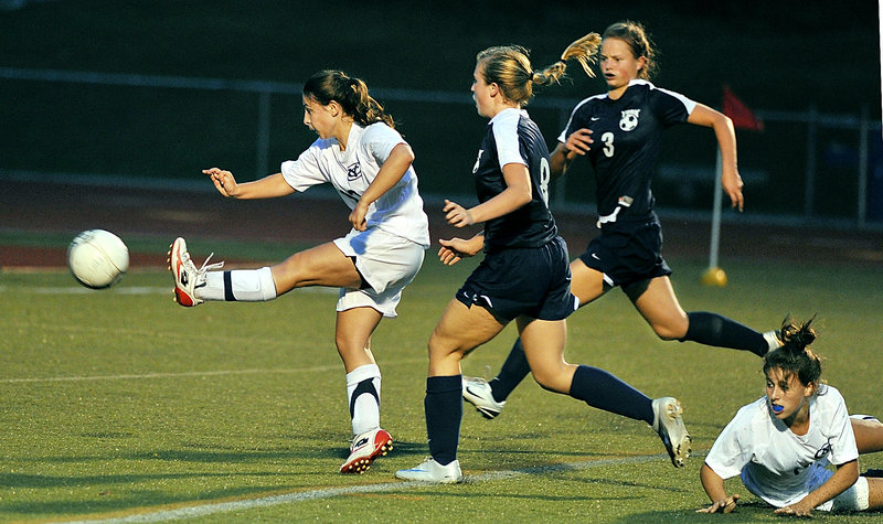 Mo McNaboe of Yarmouth unleashes a shot toward goal Thursday night after finding room behind Caitlin Kelly, foreground, and Addie Labonte of York. Yarmouth won, 1-0.
