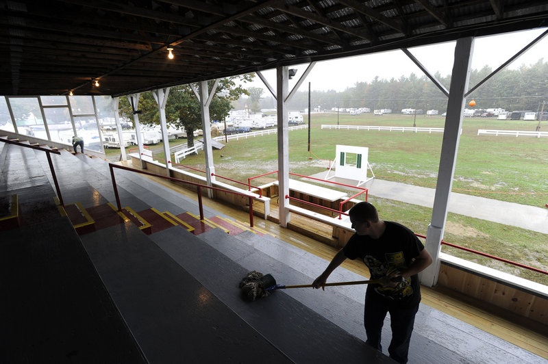 Jake Townsend and his mother Judy Townsend clean the hog and goat grandstand as they and a multitude of other workers get ready for the Fryeburg Fair, which opens on Sunday.