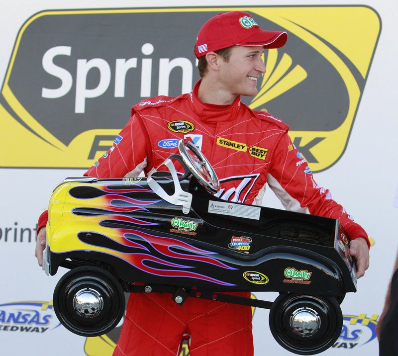 Kasey Kahne holds a peddle car, his reward for winning the pole position for Sunday’s Sprint Cup race at Kansas Speedway.