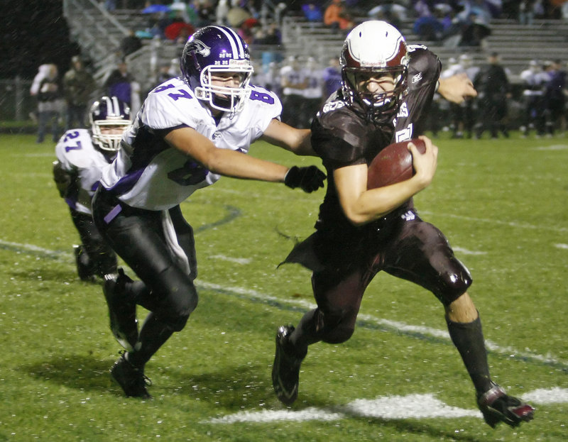 Cody Laberge, right, of Windham tries to elude Jack Verrill of Marshwood and head downfield. Laberge scored four touchdowns for the Eagles.