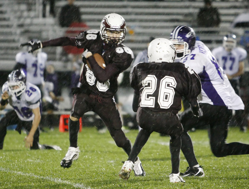 Drew Gagnon, left, of Windham sets up a block by Damien Sheppard on Marshwood’s Jack Verrill and tries to turn the corner during Windham’s 35-6 victory Friday night.