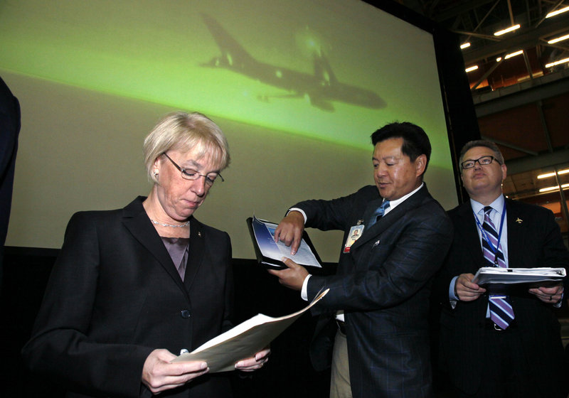 Sen. Patty Murray, D-Wash., left, goes over her notes as she stands with Boeing officials before a rally at Boeing’s production facility in Everett, Wash., last week. She has improved her standing in the polls of late and Democrats have set aside money for advertising if she needs it.