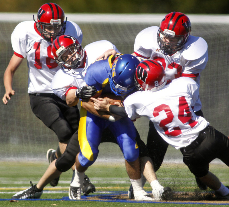 ABOVE: Falmouth quarterback Zach Alexander is on his own Saturday as the Wells defenders reach the backfield. Helping to gang-tackle Alexander are Brandon Pridham, 18, J.T. Sherburne, Joey Spinelli, 24, and Josh Ingalls, 83. Wells had few problems in rolling to a 41-8 victory on the road. BELOW: As the offensive line clears the way, Caleb Bowden of Falmouth runs through a huge hole in the first half. The Yachtsmen were only able to total 103 yards and nine first downs, however, and suffered a second consecutive loss.