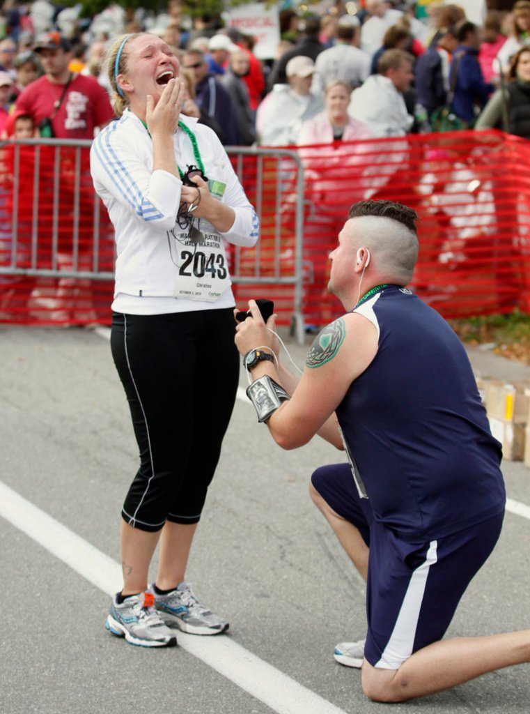 Christina Baker, left, accepted Shawn McCarthy’s proposal for marriage at the finish line after the couple from Grafton, Mass., completed the half marathon.