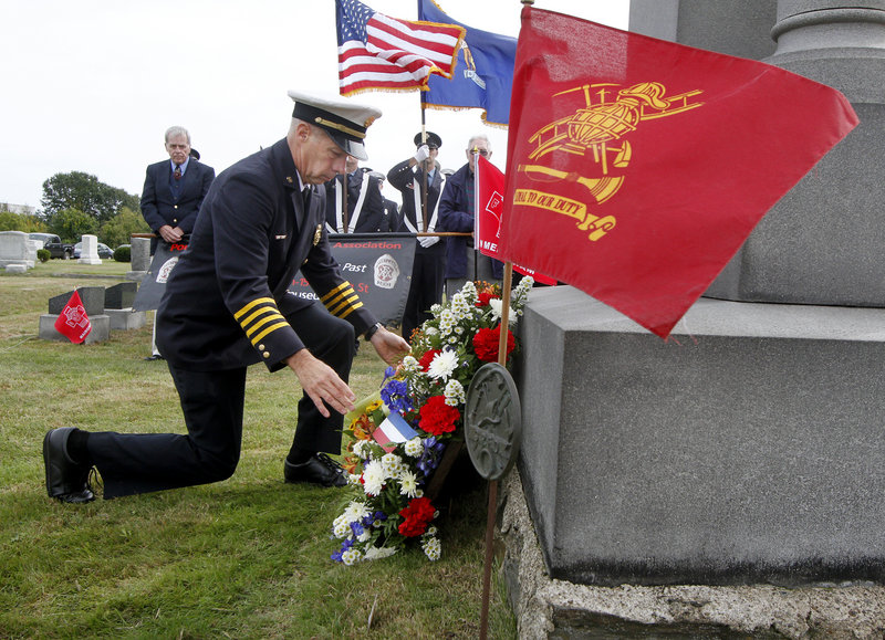 Robert Wassick, deputy chief of the Portland Fire Department, lays a wreath beside the Portland Veteran Firemen’s Association Monument on Sunday during a ceremony in Forest City Cemetery to honor lost firefighters from Portland and South Portland.