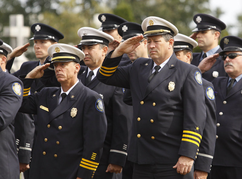 Portland firefighters salute during a ceremony in Forest City Cemetery Sunday. Since 1903, 20 Portland firefighters and two South Portland firefighters have died in the line of duty.