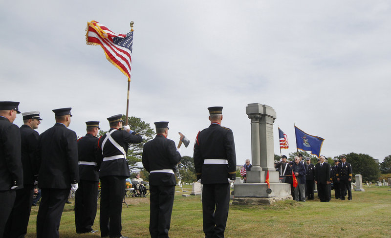 Portland and South Portland firefighters line up around the Portland Veteran Firemen’s Association Monument on Sunday. More than 60 people turned out to honor fallen firefighters.