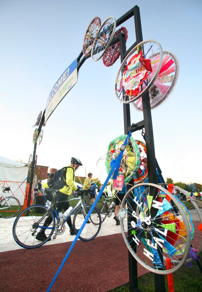 Bicycle rims decorate the entrance as cyclists arrive at Simard-Payne Police Memorial Park to register before the start of the Dempsey Challenge in Lewiston on Sunday.