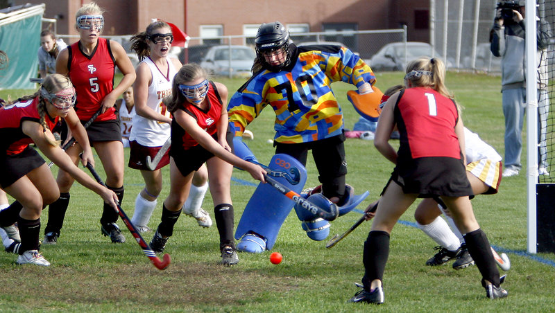 Jaclyn Salevsky, center, of South Portland swats the ball toward the goal as Thornton Academy goalie Abbey Siulinski moves out to block the shot Monday in Saco. Thornton got three second-half goals for a 4-2 victory.