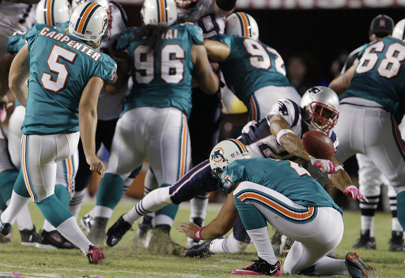 New England’s Patrick Chung gets the jump on Miami kicker Dan Carpenter and holder Brandon Fields to block an attempted field goal during the second half Monday night in Miami. The Patriots scored 35 second-half points to pull away from the Dolphins.