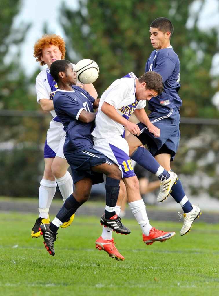Ralph Houanche, front left, of Portland collides with Nicholas Melville of Cheverus as they battle Cheverus’ Parker Doyon and Portland’s Fazal Nabi for control of the ball.