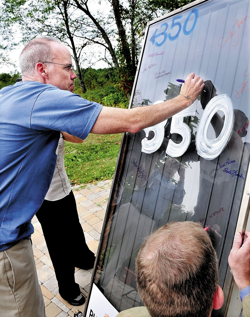 Environmental activist Bill McKibben signs a solar panel at Maine’s Unity College in Unity last month. McKibben and students took the panel, which was once installed atop the White House, back to Washington to argue for reinstalling solar panels on the White House roof.
