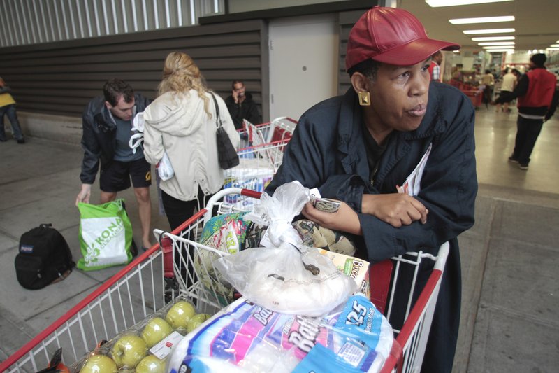 Pia James, who lives on a disability income, leaves Costco in New York City last week. Shoppers trying to stretch their dollars say they are carefully scrutinizing prices and have a game plan of what to buy where.