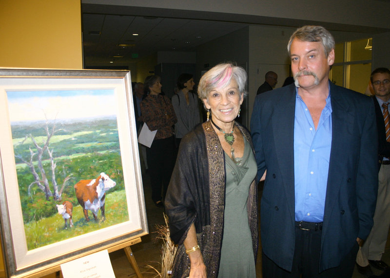 Artist Alice Ingraham and her husband, Craig Hurd, stand next to her piece in the art auction titled “New.”
