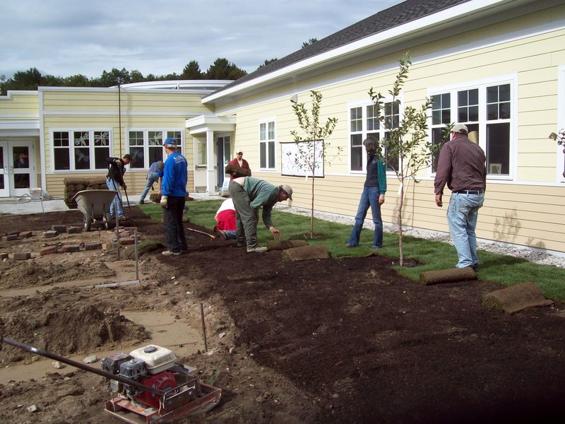 Volunteers work around fruit trees that have been planted, spreading compost in some areas and sod in others at Morrison Developmental Center in Scarborough. The center provides assistance to adults with developmental disabilities. The food grown in the new garden willbe used in the center’s kitchen and in group homes, and the excess donated to soup kitchens.