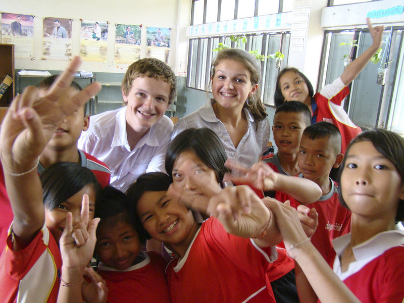 Logan, left, and Jackson Marshall sit in for a group picture with children at a school in Thailand, where they and their parents taught English – one of several working stays the family made as part of an international experience this year.