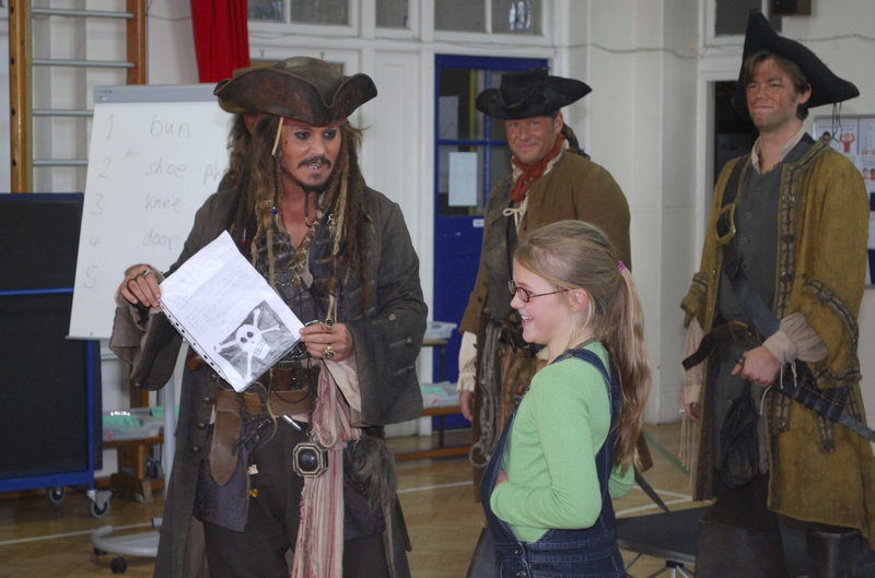 Actor Johnny Depp, left, holds a letter from 9-year-old Beatrice Delap, right, inviting him to attend her Meridian School assembly. Depp, dressed as his character Jack Sparrow from the “Pirates of the Caribbean” movie series, is currently filming the latest installment nearby.