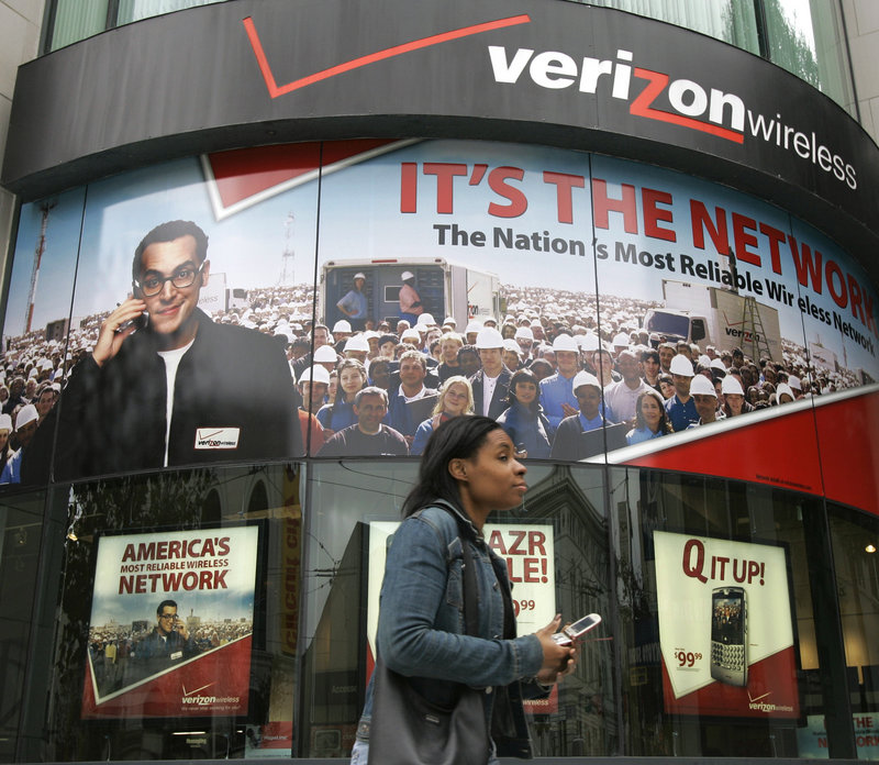 A woman with a cell phone walks past a Verizon Wireless store in San Francisco. The recent announcement that Verizon Wireless wrongly charged 15 million customers for data fees and will shell out $50 million in reimbursements has contributed to mounting consumer irritation over confusing language, third-party charges and mystery fees on their bills for wireless service.