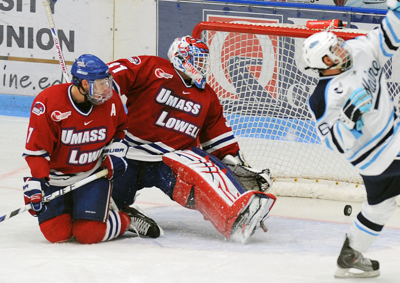 UMass-Lowell defenseman Maury Edwards, left, and goalie David Carr watch as the puck slides into the goal after Adam Shemansky of Maine’s shot in the first period Friday night. The Black Bears won their opener, 8-2.