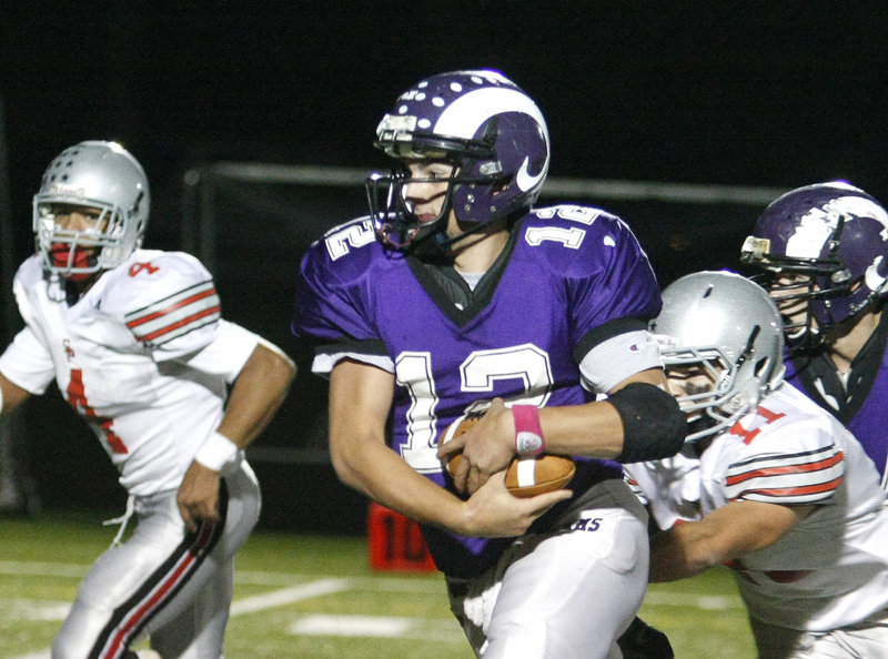 Deering quarterback Jamie Ross has a firm grip on the ball as he gets pressure from South Portland s Stephen Hodge, right, and Jacob Stanley, left, in first-half action of the Rams 35-0 win Friday night at Deering.