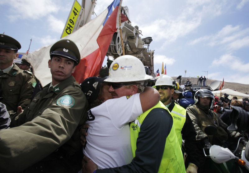 Maria Segovia, sister of trapped miner Dario Segovia, embraces Jeff Hart, operator of the T-130 drilling machine being used to reach 33 trapped miners, as the drill leaves the San Jose mine Monday near Copiapo, Chile.