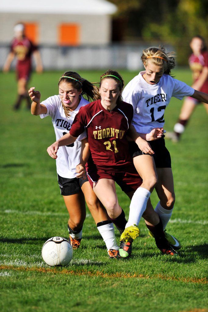 Megan Crepeau, left, and Olivia Jones of Biddeford put the squeeze on Thornton Academy’s Kaitlyn Hall during their SMAA soccer game Monday at Biddeford.