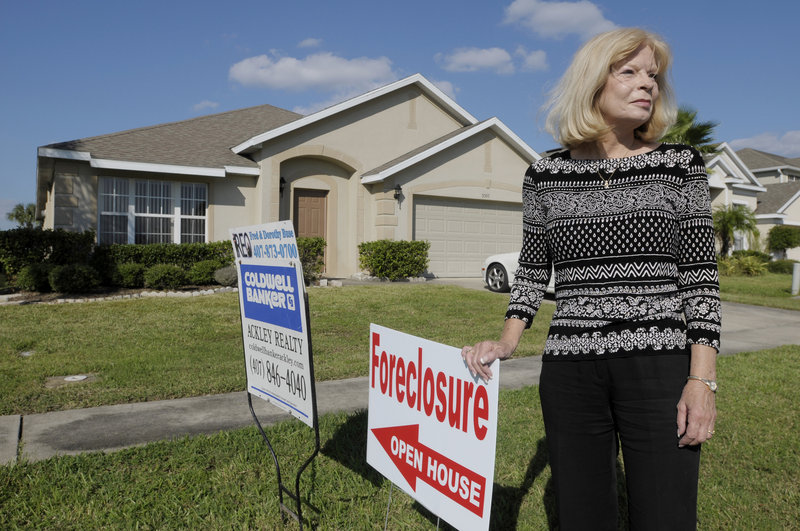 Realtor Dorothy Buse is seen in front of a foreclosed Kissimmee, Fla., home Wednesday. An announcement of an inquiry by up to 40 state attorneys general into banks’ use of flawed foreclosure paperwork could come as soon as today.