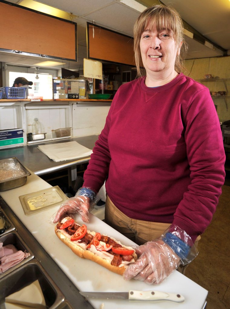Deb Carter, owner of Deb s Sandwich Shop in South Portland, prepares lunch for a customer.