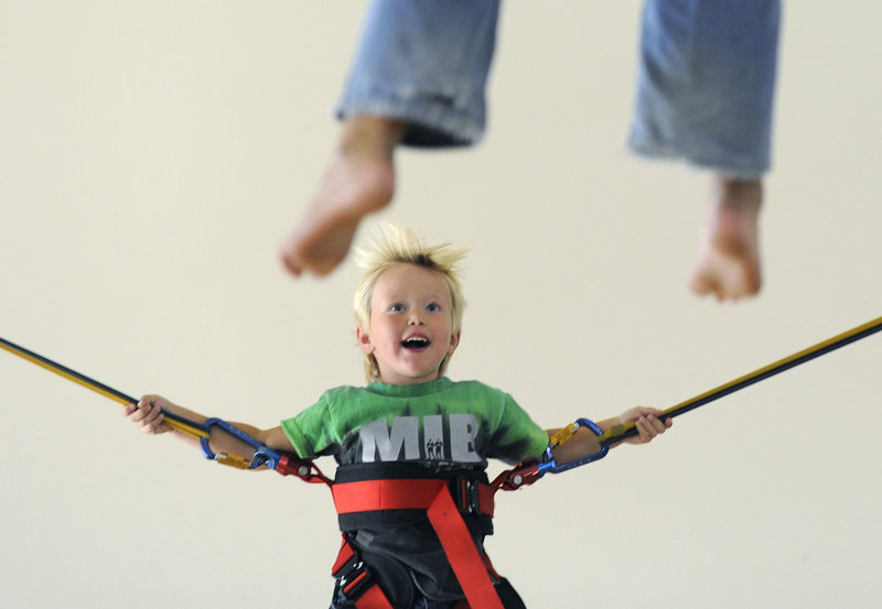 Nicholas Moulton, 4, of New Gloucester tries out the bungee-jumping trampoline at the new Extreme Family Entertainment Center, set up in the former Linens ‘N Things space at the Maine Mall in South Portland.
