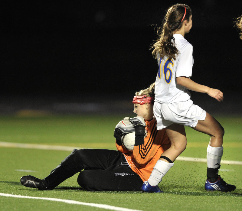 Yarmouth goalie Olivia Smith makes sure to control the ball as Jesse L'Hereux of Falmouth waits for a rebound that never came during their scoreless tie Tuesday.