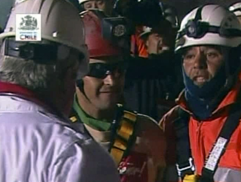 Florencio Avalos, center, the first miner to be rescued, steps from the capsule late Tuesday.