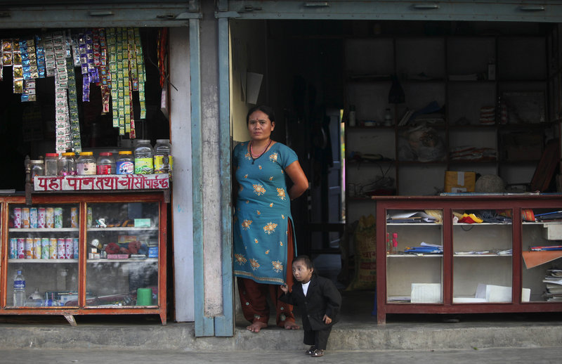 Khagendra Thapa Magar stands with his mother outside their home Wednesday in Pokhara, Nepal. Thapa is likely to be declared the shortest man in the world today after official measurements.
