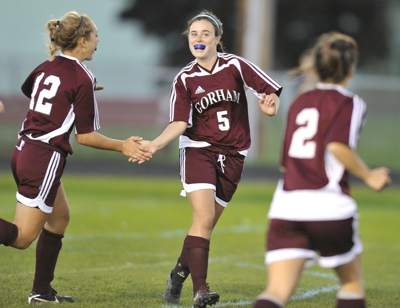 Kali St. Germain, center, gets congratulated by Audrey Adkison, left, and Sierra Peters after scoring Gorham s first goal during an SMAA girls soccer game Wednesday night against South Portland. The Rams improved to 9-3 with a 3-0 victory.