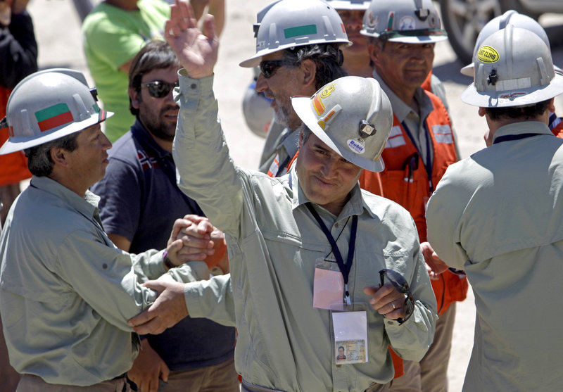 Chilean mine rescue worker Manuel Gonzalez, the first rescuer to reach the trapped miners, waves after a news conference at the San Jose mine on Thursday.