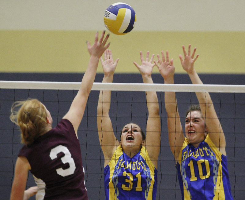 Maggie Bradley, left, of Greely goes for a spike while defended by Falmouth’s Jenna Serunian, center, and Jackie Keroack during Falmouth’s volleyball victory Thursday.