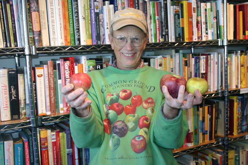 John Bunker shows off a Fameuse, a Macoun and a Gray Pearmain apple while stopping at Rabelais books in Portland to drop off rare apples distributed as part of the Out on a Limb CSA.