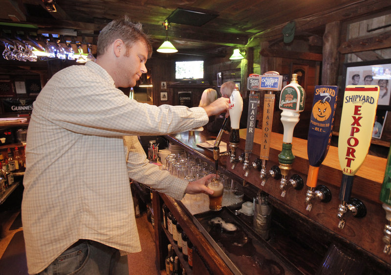 Ryan Kerry pours a black and tan at The Kerrymen Pub in Saco. The pub's autumn version of the longtime favorite is half Shipyard Pumpkinhead ale and half Guinness stout.