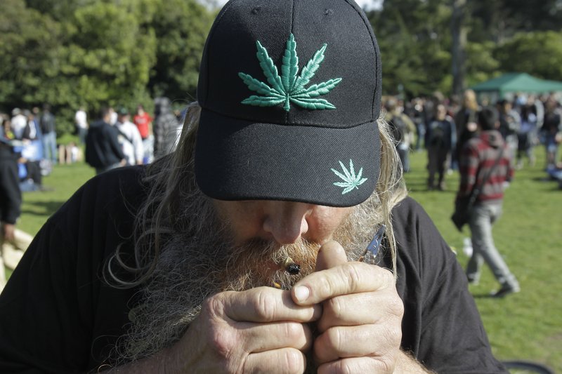 A man smokes marijuana at Golden Gate Park in San Francisco as part of a civil protest last spring. A measure on California’s ballot would let adults possess and grow the drug. Federal officials, however, say they would ignore such a state law and ‘vigorously enforce’ their own ban.
