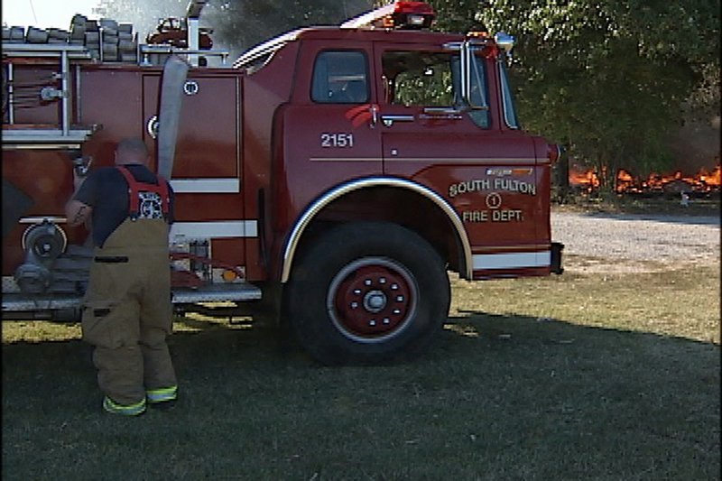 A photo taken from a videotaped image shows firefighters preparing to leave the area as Gene Cranick’s home burns in South Fulton, Tenn., on Sept. 29. Local firefighters let Cranick’s mobile home burn to the ground because the Cranick family hadn’t paid an annual $75 fire protection fee, authorities said.