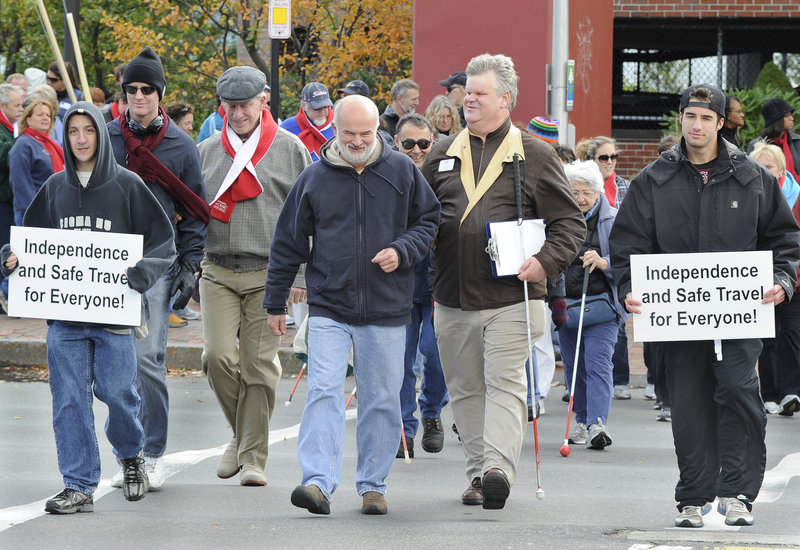 Actor and entertainer Tom Sullivan, third from left in gray cap, and Jim Phipps, fifth from left, executive director of The Iris Network, lead the annual White Cane Awareness Walk in Portland on Saturday. Participants raised awareness for the visually impaired as they walked a loop through downtown that started and ended at the Maine State Pier.