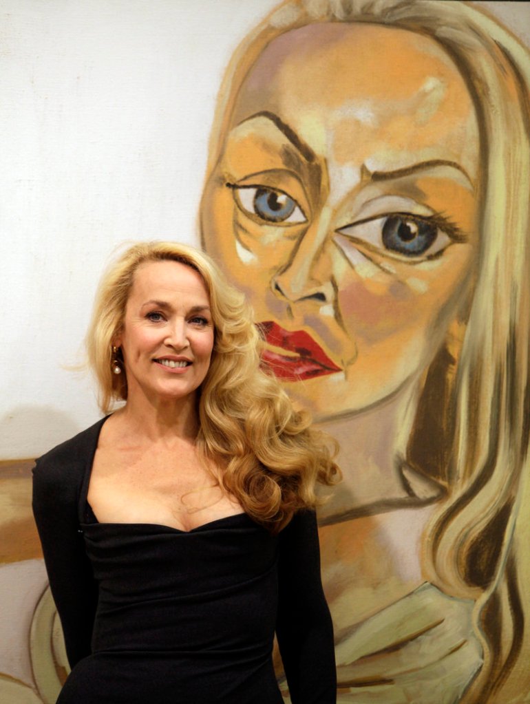 Model and actress Jerry Hall poses with Francesco Clemente’s 1997 oil on canvas titled “Jerry Hall,” one of the artworks auctioned Saturday.