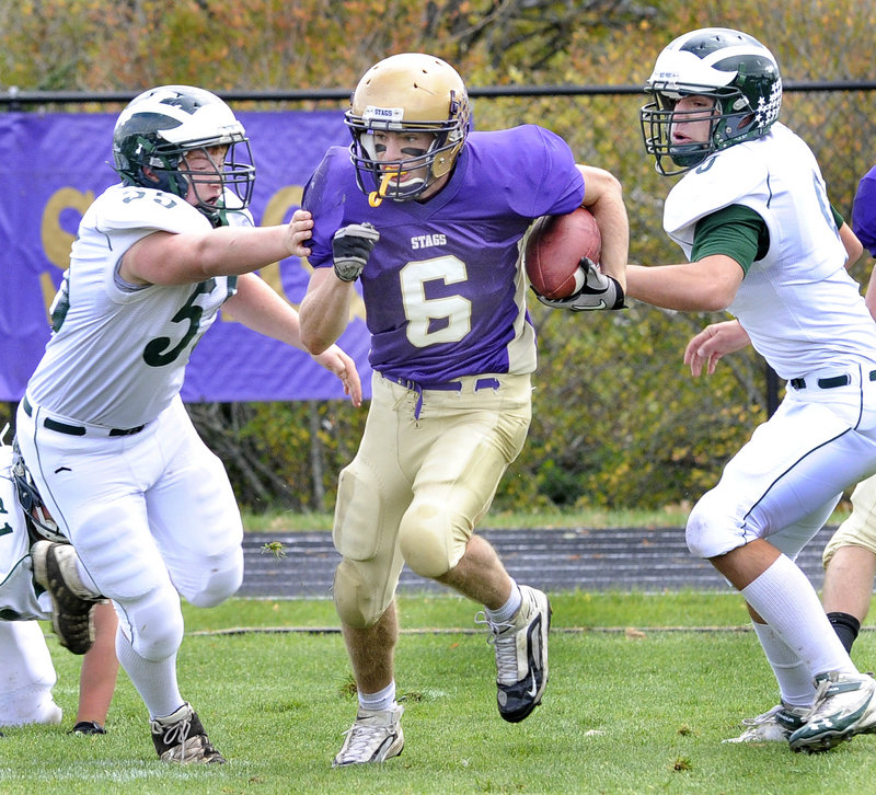 Cheverus quarterback Peter Gwilym looks for room to run Saturday between Andy Martel, left, and Jeff Amell of Bonny Eagle during their Western Class A showdown at Cheverus High. Cheverus won, 23-20.