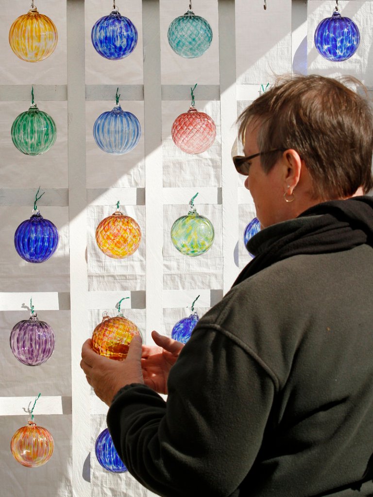 Penny Lightner of Hartford, Conn., takes a closer look at glass ornaments at a vendor booth at Harvestfest.
