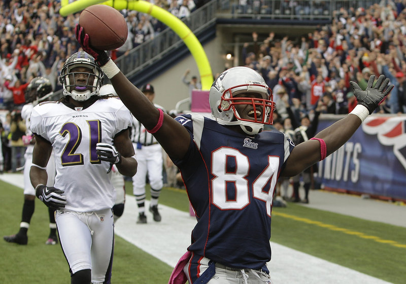 New England receiver Deion Branch celebrates a 5-yard touchdown reception over Baltimore cornerback Lardarius Webb in the fourth quarter Sunday. The catch and point-after kick cut Baltimore’s lead to 20-17.