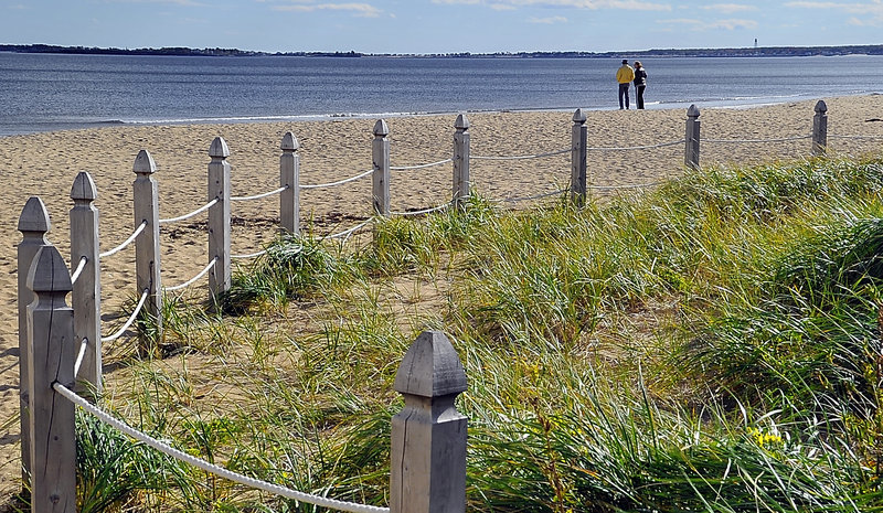Bob Gray of Arizona and his daughter, Maine resident Lynne Winans, enjoy some solitude Monday on Old Orchard Beach near a protected area of dune grass. The town's dune restoration and protection project has helped preserve delicate ecosystems along the beaches.