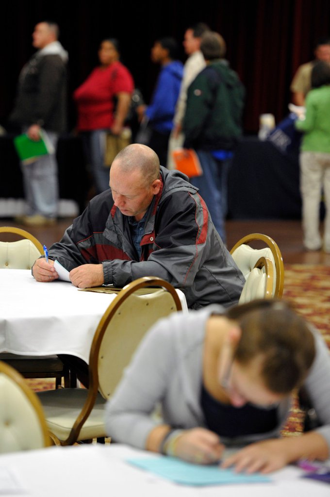 Unemployed people fill out applications at a job fair in Illinois Oct. 5. A reader says not enough is being done for people like them.