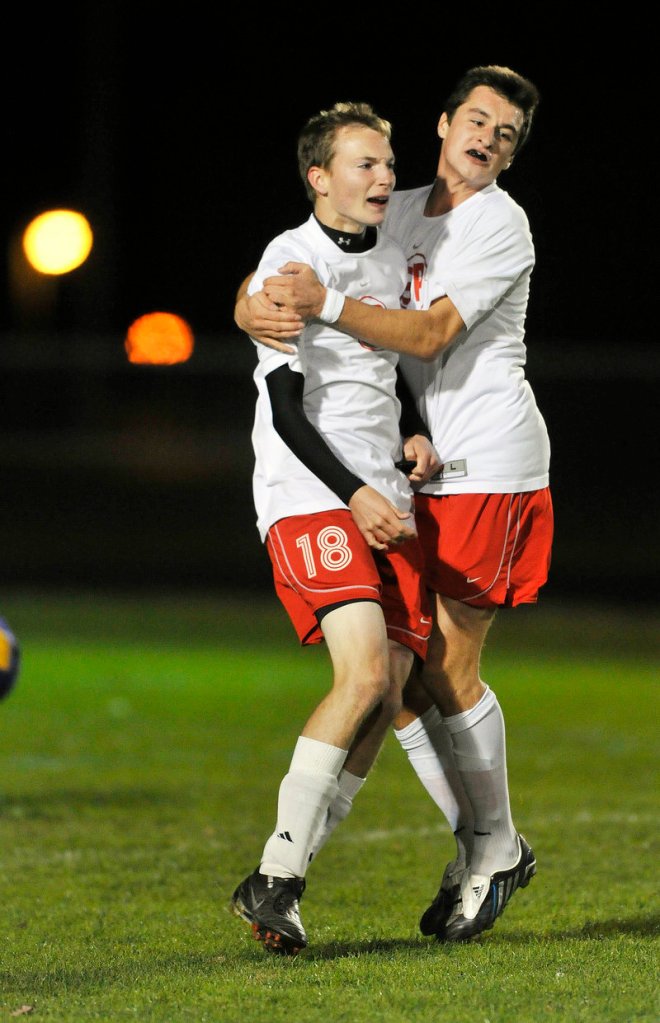 Dan Grazewski, left, gets a hug from Damjan Draskovic after scoring the first goal Monday night for South Portland against Cheverus. Draskovic also scored in the Red Riots 3-0 win.