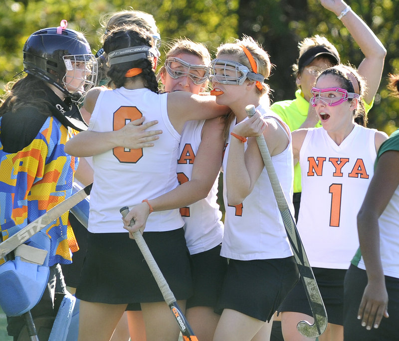 The stoic expression of Waynflete keeper Kailina Mills, left, contrasts with the celebration of NYA players left to right, Katherine Millett, Megan Fortier, Hannah Hearn and Sasha McLean on Millett's first goal Tuesday in Yarmouth.