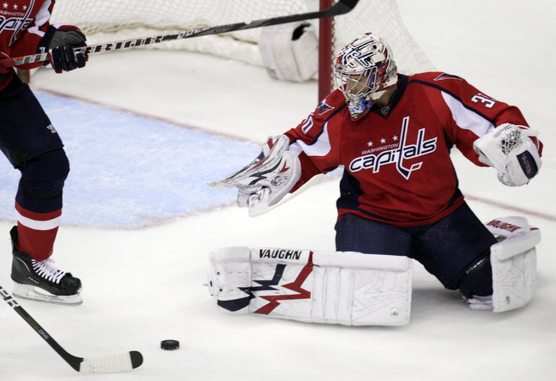Washington goalie Michal Neuvirth looks on Tuesday night as Boston left wing Milan Lucic, stick at left, scores during the first period of their game at the Verizon Center in Washington. The Capitals had won four straight.